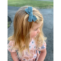 ThisLittlePiggyBowCo. coastal blue gauze small hand-tied hair bow model in lifestyle imagine.