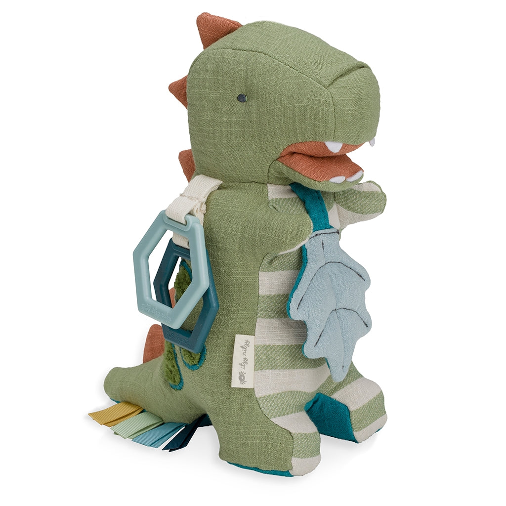 Itzy Ritzy activity plush dino with teether toy against white backdrop
